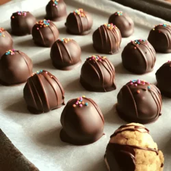 Creating cookie dough truffles is simple and fun. You will need basic ingredients to make these tasty treats. I love how no baking is involved, which makes this recipe even better. You can whip up a batch in no time! Here’s what you will need: - 1 cup all-purpose flour (heat-treated) - ½ teaspoon baking soda - ½ teaspoon salt - ½ cup unsalted butter, softened - ½ cup brown sugar, packed - ¼ cup granulated sugar - 2 teaspoons vanilla extract - ½ cup chocolate chips - 1 cup semi-sweet chocolate chips (for coating) - 1 teaspoon coconut oil (optional, for chocolate coating) You can add fun extras to make your truffles unique. Here are some ideas: - Chopped nuts for crunch - Peanut butter for a nutty twist - Mini marshmallows for a sweet touch - Sea salt for a savory bite - Different chocolate chips for variety Feel free to mix and match these options! The full recipe provides a great base to create your favorite flavors. Enjoy experimenting! To start, gather your ingredients. In a small bowl, mix the flour, baking soda, and salt. Set this bowl aside. In a large mixing bowl, cream the softened butter with both sugars. You want it light and fluffy, which takes about 2 to 3 minutes. Next, add the vanilla extract and mix until it blends well. Gradually add the flour mixture to the wet ingredients. Mix on low speed until just combined. Finally, fold in the chocolate chips. This way, they spread evenly in the dough. Now it’s time to shape the dough. Use your hands to form small balls, about 1 inch in diameter. Place them on a baking sheet lined with parchment paper. Once all the dough is shaped, freeze the truffles for about 30 minutes. This helps them firm up and hold their shape. Next, melt the chocolate chips. Use a microwave-safe bowl and heat in 30-second intervals, stirring in between. If you like, add coconut oil for a smoother coating. Remove the truffles from the freezer. Dip each one into the melted chocolate, rolling it around with a fork until fully coated. Place the coated truffles back on the parchment-lined sheet. Before the chocolate sets, sprinkle some leftover chocolate chips or colorful sprinkles on top. Finally, refrigerate the truffles for 15 to 20 minutes, until the chocolate hardens. Enjoy your cookie dough truffles! For the full recipe, check out the detailed instructions above. To stop your cookie dough from spreading too much, always chill it first. Keeping the dough cold helps it hold its shape. After mixing, roll the dough into balls and freeze them for at least 30 minutes. This simple step can make a big difference. You can also use a little less butter in your recipe. Too much fat makes the dough spread more. Remember, firm dough is the key to perfect truffles. Melting chocolate can be tricky, so follow these tips. Use a microwave-safe bowl and heat the chocolate in short bursts. Start with 30 seconds, then stir. Repeat until smooth. Be careful not to burn the chocolate. Adding a teaspoon of coconut oil can help make it shinier and smoother. If you don’t have a microwave, use a double boiler. Just let the steam melt the chocolate gently. This method keeps the chocolate from getting too hot and helps avoid lumps. To make your cookie dough truffles even better, try adding extra flavors. A pinch of cinnamon can give a warm taste. Chopped nuts add crunch and depth. You can also mix in dried fruits like cranberries or raisins for a sweet touch. Want a unique twist? Try using peanut butter chips instead of chocolate chips. These add-ins can bring new life to your truffles. Explore and find your favorite combinations for a fun treat. For the full recipe, check out the detailed steps above! {{image_2}} You can make vegan cookie dough truffles with simple swaps. Use coconut oil instead of butter. Replace the brown sugar with coconut sugar for a rich taste. Choose dairy-free chocolate chips for coating. These changes keep the truffles tasty and plant-based. For gluten-free cookie dough truffles, swap regular flour for almond or oat flour. Both options work well and keep the texture nice. Just remember to check that your chocolate chips are gluten-free too. This way, everyone can enjoy these treats without worry. Get creative with flavor! Try adding peanut butter or almond butter to the dough. For a fun twist, mix in crushed Oreos or sprinkles before freezing. You can also use flavored extracts, like almond or mint, to change things up. The options are endless and exciting! For the full recipe, check out the details above to get started. To keep your cookie dough truffles fresh, store them in the fridge. Use an airtight container to prevent drying out. Place a layer of parchment paper between layers if stacking them. They will stay good for about one week in the refrigerator. Freezing is a great option for longer storage. After dipping the truffles in chocolate, let them set. Then, place them in a single layer on a baking sheet. Freeze them for about two hours. Once firm, transfer them to a freezer-safe bag or container. They can last up to three months in the freezer. Just remember to thaw them in the fridge before enjoying! The shelf life of your cookie dough truffles depends on storage. In the fridge, aim to consume them within seven days. For frozen truffles, try to eat them within three months for the best taste. To enjoy them at their best, let frozen truffles sit in the fridge for a few hours before serving. This way, they will soften slightly and enhance their flavor and texture. Want more tips? Check out the Full Recipe for all the details! Yes, you can eat cookie dough truffles raw. They contain no eggs, which makes them safe to consume. The flour must be heat-treated first to kill any harmful bacteria. You can do this by baking the flour at 350°F for five minutes. This process makes the dough safe and delicious. To make cookie dough truffles without eggs, simply skip them in the recipe. The other ingredients provide enough moisture and flavor. The butter and sugars create a creamy texture, while the heat-treated flour holds everything together. You’ll still get that cookie dough taste without using eggs. You can get creative with toppings for cookie dough truffles. Here are some popular options: - Mini chocolate chips - Sprinkles - Crushed nuts - Sea salt - Coconut flakes - Colored sugar These toppings add fun and texture. You can mix and match to find your favorite combination. For more details and tips, check the Full Recipe. You learned how to make delicious cookie dough truffles. We covered the key ingredients, including options for better flavor. The step-by-step instructions make it easy to prepare and shape your truffles. Tips help you avoid common mistakes and improve taste. Variations offer choices for every diet. Storage info ensures your treats stay fresh. Now, it's time to get creative and enjoy your tasty truffles!